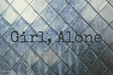 ‘Girl, Alone’ written in front of diamond-patterned translucent glass