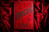 A red hardback copy of Dracular on red velvet.