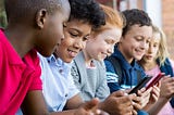 Five elementary school students on their phones.