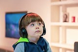 Young child wearing oversized bose headphones