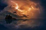 Dramatic clouds with lightning reflected on water below.