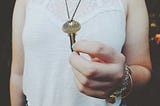 Person holding a key with the word “fearless” engraved on it.