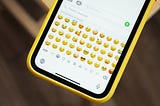 Photo of a phone displaying the emoji keyboard.