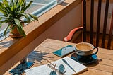 experts take on editing. A writing notebook, coffee cup on a small writing desk. It is a roadside cafe.
