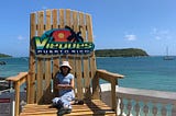 Mina sitting in a huge wooden chair (a tourist attraction), in Vieques, Puerto Rico.