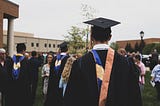 College graduation day. Men and women in graduation gowns and caps.