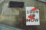 A sign that reads “1984 is now”.