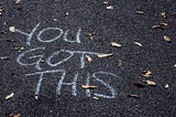 Chalk on asphalt. The words “You got this”.