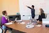 Person showing diagrams at a whiteboard