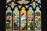 A stained-glass window depicting the crucifixion of Jesus (bottom panes) and his resurrection and ascension (top panels) in St. Giles' Cathedral (Sep., 2021).