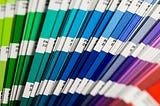 A collection of Pantone color swatches ranging from green to blue, to purple, to red.