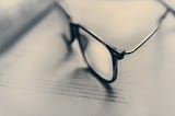 Glasses blurred on top of an opened book.