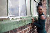 Lovely Black woman near an old building