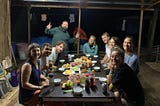 People at a table having dinner on a wooden floating house