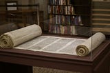 Torah scroll open on a reading desk.