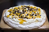 A delicious dessert of meringue topped with whipped cream and fruit. (This one has chocolate too —a step too far!)