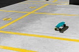 An aqua colored skateboard sitting in the middle of a parking lot.