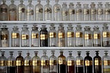 Apothecary style glass bottles and jars lined up on a shelf