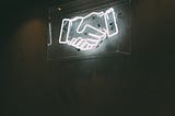 Neon sign of a handshake