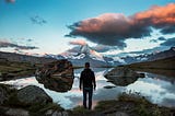 A man on a horizon of mountains.