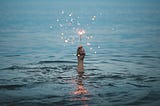 Submerged person holding a sparkler