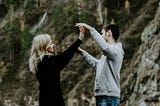 A man and woman holding hands while smiling at each other.