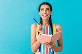 Woman with pencil in hand thinking about what to write in her journal