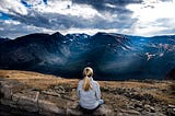 A woman is looking to a mountain