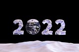 2022 written as big blocks of snow-covered ice with the zero represented by the Earth