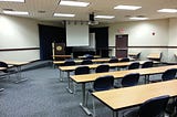 A college classroom with seating and a podium