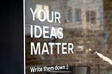 Window featuring‘Your ideas matter, write them down’ in white lettering.