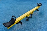 An image of a seesaw on a playground.