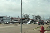 Damaged building with debris close to street, located in Lake Charles.