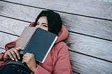 Woman with a notebook, thinking about a decision.