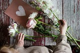 wooden table with cut fresh flowers being arranged by woman, mothers day 2024, mothers day calendar date, mothers day gift ideas, last minute mothers day gifts