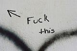 paper with words “fuck this” and an arrow