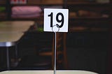 Number nineteen written on a paper with a stand.