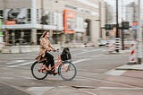 A woman riding a bike through an intersection.