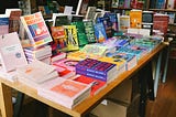 A bunch of books on the desk from a bookstore.