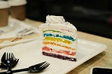 Nommy looking piece of rainbow cake