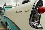 View of a classic turquoise and cream 57 Chevy, from the back tail light.