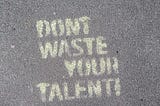 Graffiti on concrete that reads “Don’t Waste Your Talent.”