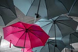 A red umbrella among black umbrellas.