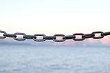 close-up of a heavy chain, with a body of water in the background