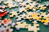 A picture of loose yellow colored jigsaw puzzle pieces