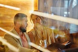 A photo of a man and woman sitting across each other having coffee