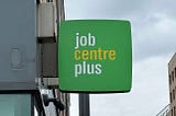 A green building sign reading “job centre plus.”