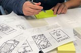 a person sitting down to draw out prototypes