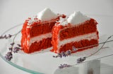 Two slices of red cake with white icing.