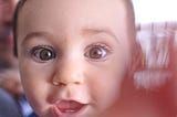 a baby’s face up close, wide eyes and open mouth, Mary Mahoney, Medium